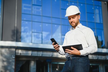 Architect in helmet near new building