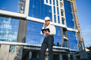 Construction engineer with the tablet pictures of objects on a construction site