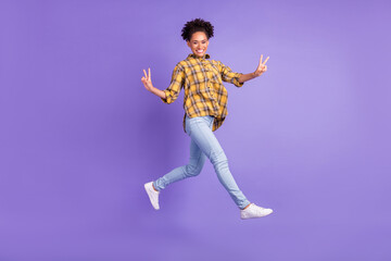 Fototapeta na wymiar Full body profile side photo of young afro girl happy positive smile jump show v-sign isolated over purple color background