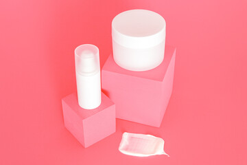 White unbranded cosmetic cream jars group standing on pink podiums. Skin care product presentation on the pink background. Trendy mockup. Skincare, beauty and spa.