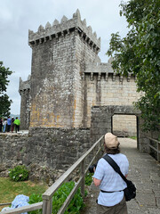 a photographer prepares to take pictures of students at the gate of a castle