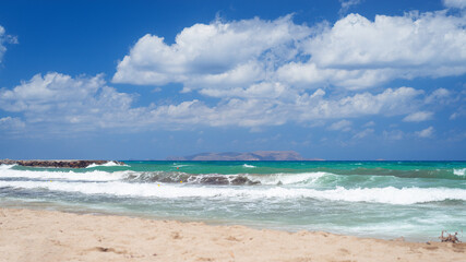 azure sea with waves against a blue cloudy sky in clear weather