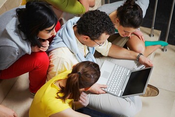 University students sitting on floor with laptop