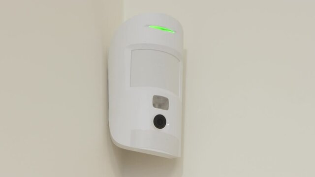 Indoor security system equipment, smart motion detection, wireless motion detector on the wall, infrared sensor sends an alarm signal to security company. High quality 4k footage