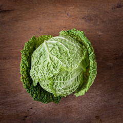 Fototapeta premium Fresh savoy cabbage on wooden background. Harvest concept. Top view.