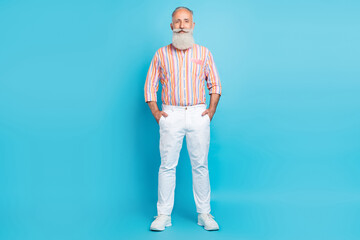 Photo of successful retired businessman hands pockets wear striped shirt pants shoes isolated blue color background