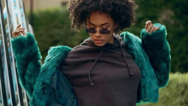 African american woman in stylish futuristic clothes dancing on street, hobby