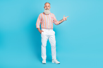 Full body photo of aged man happy positive smile point finger empty space ad direct recommend isolated over blue color background