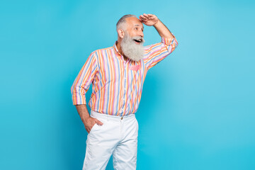 Photo of curious dreamy grandfather hand brow look empty space wear striped shirt isolated blue...