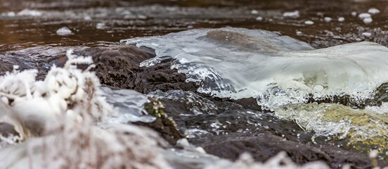 Fast river with ice and snow in late autumn