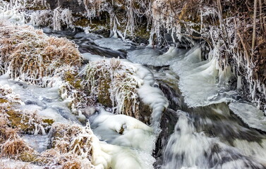 Fast river with ice and snow in late autumn