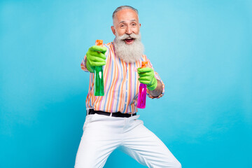 Photo of crazy retired old man hold two sprayer bottle pretend shoot wear striped shirt isolated blue color background - Powered by Adobe