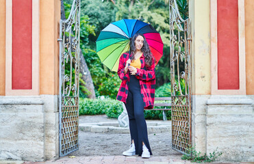 Fototapeta na wymiar girl with rainbow umbrella in the park