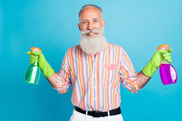Photo of aged man happy positive smile housework sprayer dust clean service isolated over blue color background