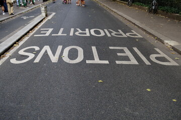 Priorité piétons. Inscription à l'envers sur une route asphaltée.