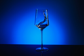 Splash of water in a glass on a blue background.