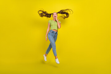 Fototapeta na wymiar Full length body size view of pretty girlish amazed cheerful girl jumping having fun isolated over bright yellow color background