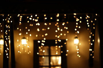 Obraz na płótnie Canvas Cozy house with garlands, window with light, background for Christmas mood. High quality photo
