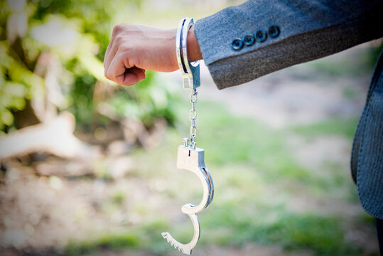 hand release shackle The man's handcuffs were opened. acquitted innocent defendant gray suit businessman cessation of criminal proceedings.
