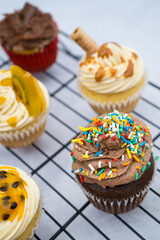 close up of a chocolate cupcake with different cupcakes on the background