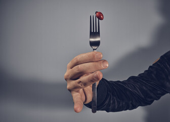 rosehip spiked on fork with male hand
