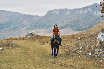 woman hiker riding a horse on nature travel