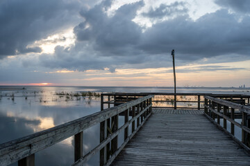 Fototapeta na wymiar Cloudy Sunset and Fishermen on the Pier