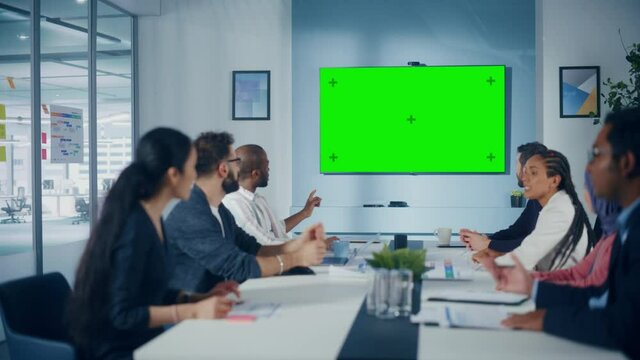 Multi-Ethnic Office Conference Room Meeting: Diverse Team of Successful Managers, Executives Talk, Use Green Screen Chroma Key TV. Businesspeople Investing in e-Commerce Startup