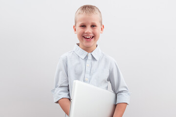 Smiling boy holding a laptop on a white background