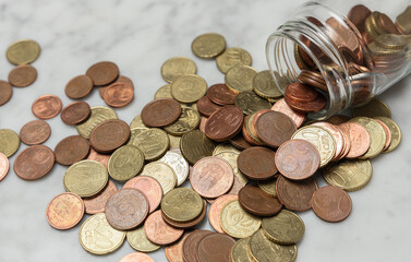 Coins spilling from a glass jar