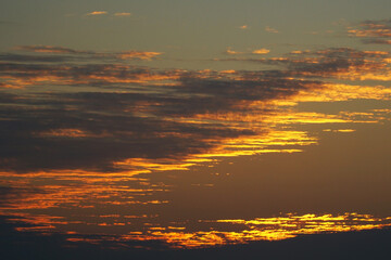  Evening sky with bright, golden and dark clouds.