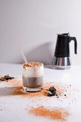 Milkshake drink with black coffee pot and chocolate pieces and cinnamon