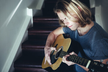 Portrait of a male musician playing guitar alone