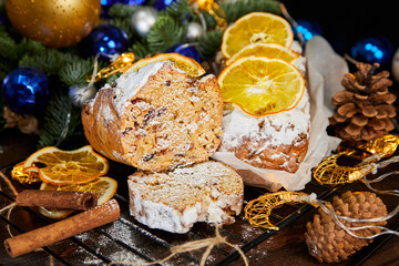 Christmas stollen with spices, raisins, nuts and candied fruits on a background of glowing garlands