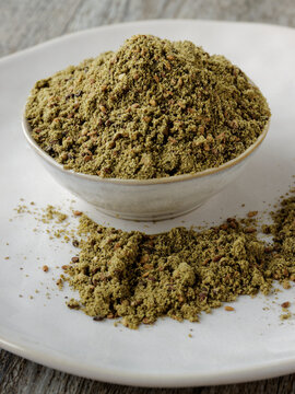 Green Za'atar spice blend heap in a bowl. Traditional Middle East zaatar condiment.