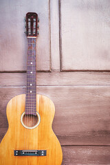 Naklejka premium Yellow traditional soprano ukulele guitar on the steps at the door of a house made of wood. Guitar in front of a wooden house with a door. Music concep.