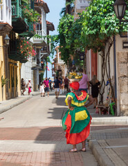 Woman dressing with vivid colours in the corner of  street of the walled city