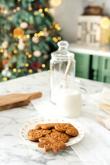 Gingerbread cookies on decorated kitchen near christmas tree. Vertical background