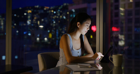 Woman work on tablet computer at room in the evening