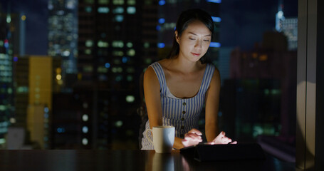 Woman work on tablet computer at room in the evening