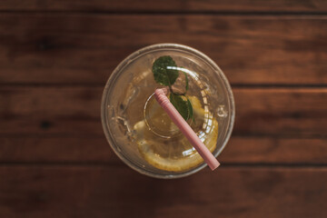 Lemon soda drink in plastic glass on wooden table in the cafe.