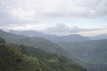 A view of the green mountains and above them the clouds
