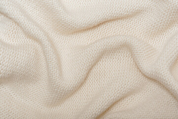 Beige knitted background with folds texture
