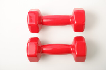 Sport equipment. Two red dumbbells for fitness weighing 2 kg on a white background.