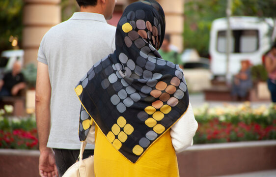 a scarf on a woman head with man