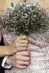 hands of young people with wedding wedding rings. wedding day details. calla flowers. spouses newlyweds groom and bride