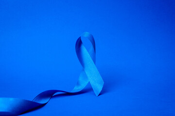 Men cancer. Awareness of men health in November with blue prostate cancer ribbon isolated on deep...