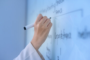 Human's hand writing on white board