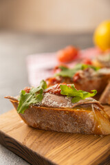delicious bruschetta with salmon avocado and arugula on a wooden board.