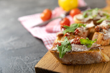 delicious bruschetta with salmon avocado and arugula on a wooden board. copy space